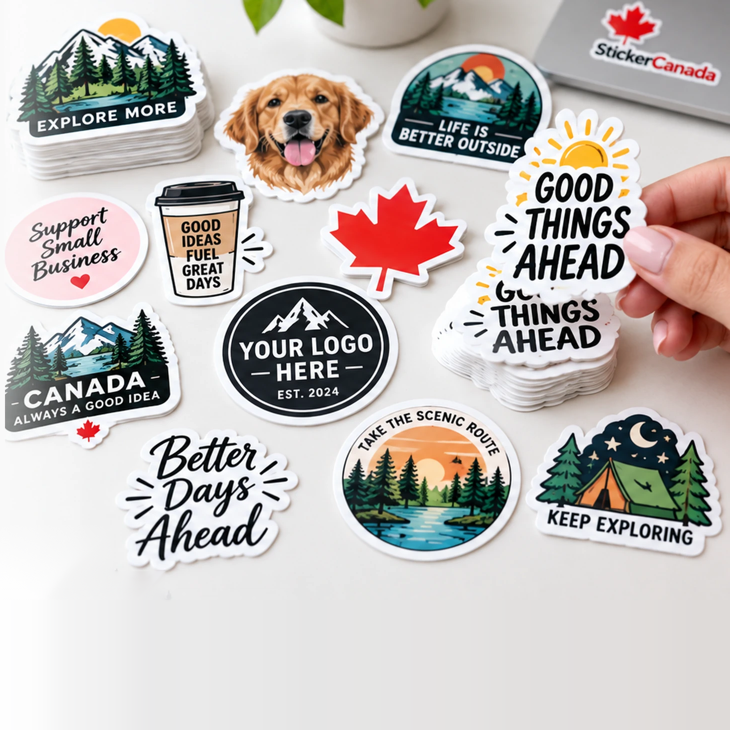 Assorted custom die-cut vinyl stickers on a desk, one being lifted from a stack